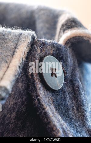 Button on a warm blue shirt, macro shot. Stock Photo