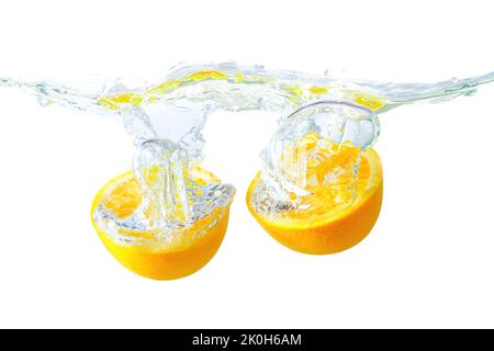 Orange halves cut wavy water surface with splashes and bubbles isolated on white background. Stock Photo