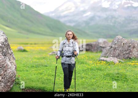 Front view portrait of a hiker walking towards you in a valley Stock Photo