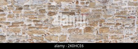 Old gray brown wall made of various natural stones Stock Photo