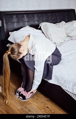 Physical or emotional exhaustion, fatigue, overtime working. Businesswoman tired after at work sitting on bed at home. Exhausted, lazy, tired, sleepy Stock Photo
