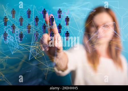 A closeup of the woman's hand pointing at the hovering people icons. Human resources concept. Stock Photo