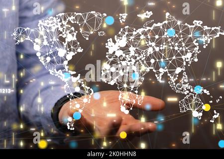 The world map with dots hovering above the person's hand. Stock Photo
