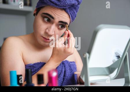 Young drag queen man applying eyeshadow. Stock Photo