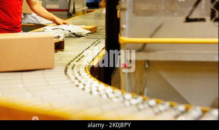 Parcel on conveyor belt in a warehouse. Stock Photo
