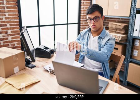 Down syndrome man ecommerce business worker reading document at office Stock Photo
