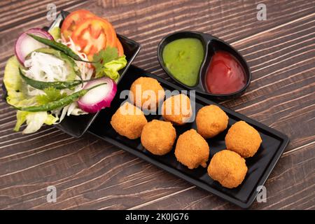 Indian Delhi Street Chaat Food Ram Laddu Pakode Or Raam Ladoo Pakore Is Made Of Moong Dal, Yellow Mung Lentils, Chana Daal. Served With White Radish Stock Photo