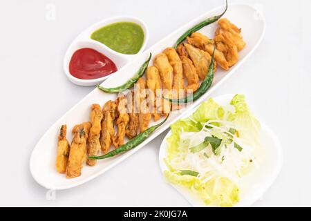 Indian Street Food Sliced Crispy Fried Potato Wedges Also Called Aloo Bhajji, Alu Bajji, Aaloo Pakoda or Pakora Made Of Bengal Gram Flour Besan Stock Photo