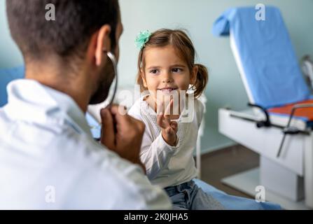 Healthcare medical exam people child concept. Close up of happy girl and doctor with stethoscope Stock Photo