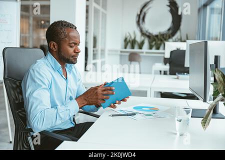 African businessman working with documents while sitting in modern office Stock Photo