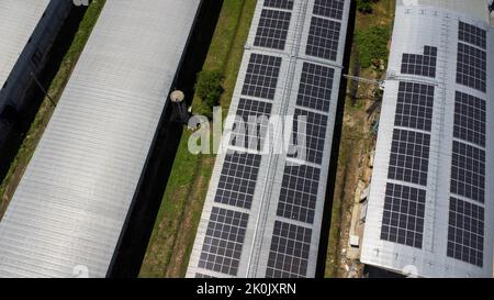 Aerial view of Solar panels installed on a roof of a large industrial building or a warehouse. Top view of solar power station with factory. sustainab Stock Photo
