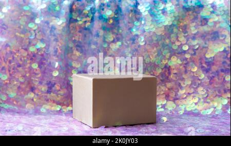 Beautiful iridescent purple color sequins textile background with square shape box pedestal for products. Lot of copy space. Side view. Stock Photo