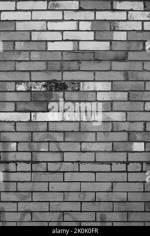 Typical common weathered brick wall in a black and white monochrome background. Stock Photo