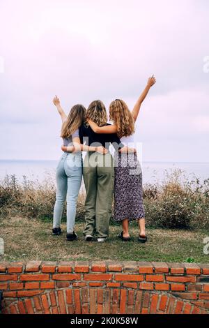 Cheerful smiling women hugging while standing in countryside Stock Photo