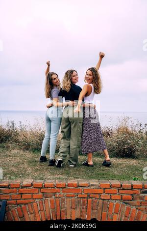 Cheerful smiling women hugging while standing in countryside Stock Photo