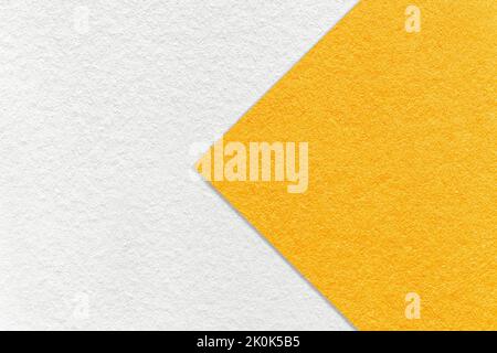 Texture of white and bright yellow paper background, half two colors with arrow, macro. Structure of dense craft orange cardboard. Felt abstract backd Stock Photo