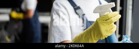 partial view of blurred cleaner in rubber glove holding detergent, banner,stock image Stock Photo