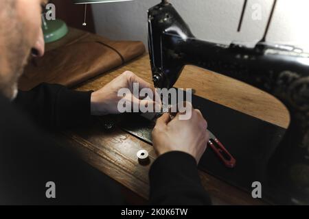 Man stitching textile in atelier Stock Photo