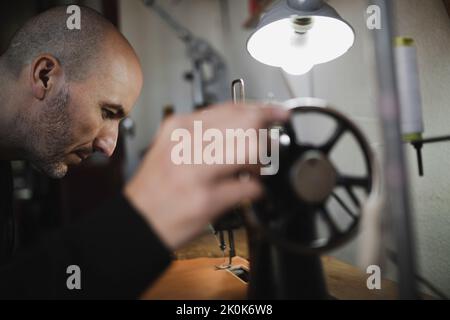 Man stitching textile in atelier Stock Photo
