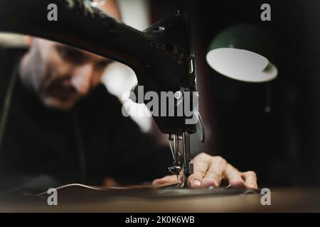Man stitching textile in atelier Stock Photo