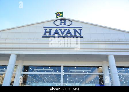 Facade of a department store in Brazil, with internal lights on the columns, with the Brazilian flag on top, in the background blue sky, sunset, Braz Stock Photo