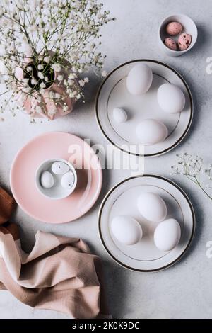 From above still life of beautiful painted Easter eggs over white table background near cute flowers Stock Photo