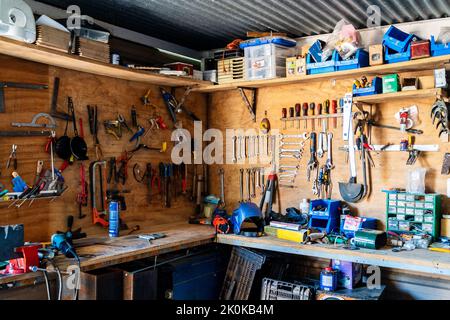 Wooden boards with various instruments and tools of joinery above workbench in modern workshop Stock Photo