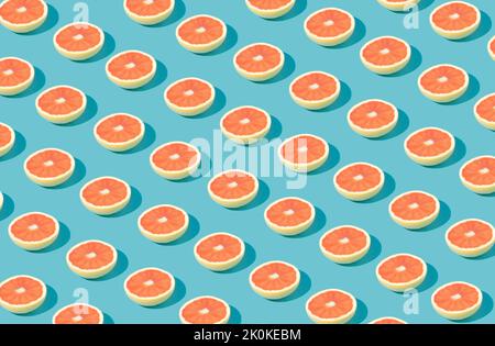 Pattern made of fresh pink grapefruit on a blue background. Minimal concept. Stock Photo