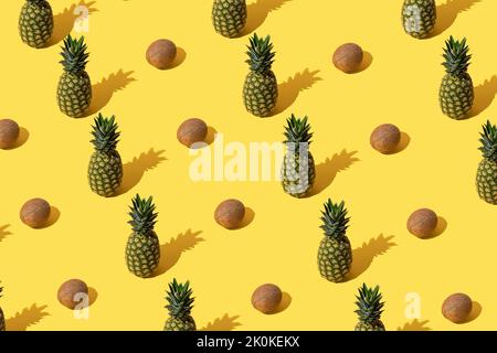 Summer pattern with pineapples and coconuts on yellow background. Stock Photo
