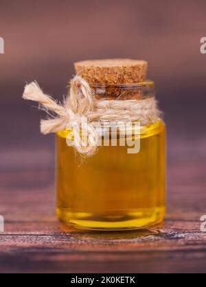 Oil in a glass jar on wooden background. For cosmetic and beauty products Stock Photo