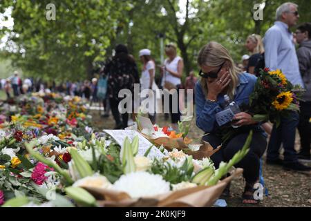 London, UK. 12th Sep, 2022. A woman reacts as she views floral tributes in Green Park, near Buckingham Palace, London following the death of Queen Elizabeth II on Thursday. Picture date: Monday September 12, 2022, London. Picture date: Thursday September 12, 2022. Credit: Isabel Infantes/Alamy Live News Stock Photo