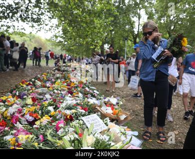London, UK. 12th Sep, 2022. A woman reacts as she views floral tributes in Green Park, near Buckingham Palace, London following the death of Queen Elizabeth II on Thursday. Picture date: Monday September 12, 2022, London. Picture date: Thursday September 12, 2022. Credit: Isabel Infantes/Alamy Live News Stock Photo