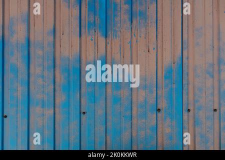 Partially painted metal fence sheet rusted in places where paint has fallen off Stock Photo