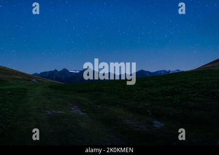 Spectacular scenery of small rural house in mountainous highlands during the evening with starry sky Stock Photo
