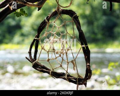 Roughly made dream catcher hanging from a tree branch on a trail in Ottawa, Ontario, Canada. Stock Photo