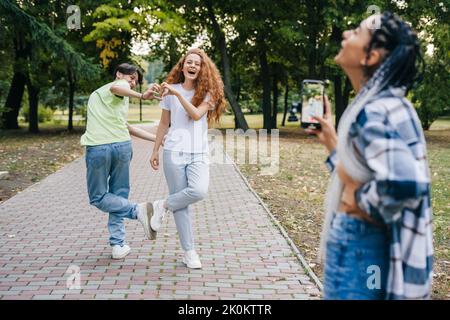 Group of teenagers internet blogger recording media content, filming video blog. Modern lifestyle concept with smart millennial guys and girls having Stock Photo
