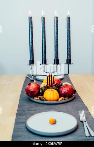 Fall table setting for celebration Thanksgiving day for two. Autumn composition with candles, pumpkins ,pomegranate and cones. Natural autumn decor. V Stock Photo