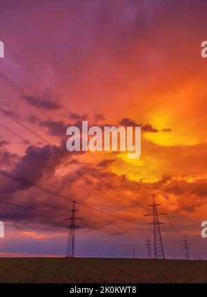 Electricity transmission power lines High voltage tower high-voltage lines. Transmission of electricity by means of supports through agricultural area Stock Photo