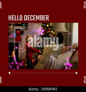 Composition of hello december text over caucasian girl at christmas Stock Photo