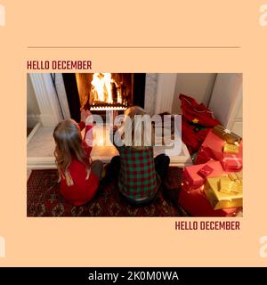 Composition of hello december text over caucasian siblings at christmas Stock Photo