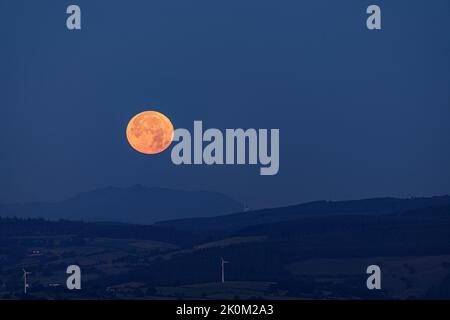 Supermoon setting over the Vale of Clwyd, North Wales Stock Photo