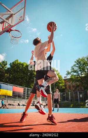 Lviv, Ukraine - May 28, 2022: men playing basketball outdoors Stock Photo