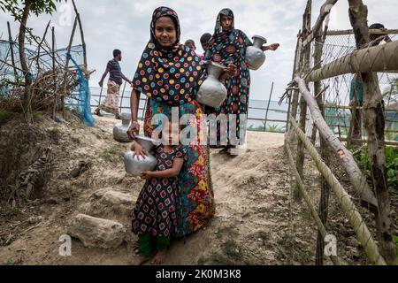 Drinking water supply and drinking water procurement from wells or freshwater ponds near Shyamnagar. The people in the small settlements along the rivers in southern Bangladesh are clearly feeling the effects of climate change. The sea level is rising and dams are being destroyed. As a result, fields and the important freshwater ponds are flooded and salinated. Therefore, great efforts are being made to fortify the banks. Residential buildings are being raised and fortified as well. Suesswater harvesting projects are very important to provide people with clean drinking water. Stock Photo