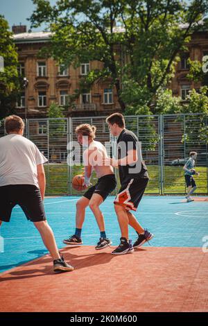 Lviv, Ukraine - May 28, 2022: men playing basketball outdoors Stock Photo