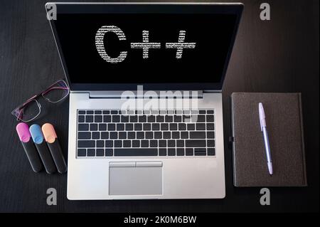 Laptop with C++ text. Top view. C plus plus inscription on laptop screen. Stock Photo