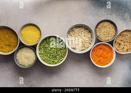 Various grain cereals in bowls on a light background, top view Stock Photo