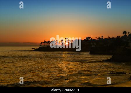 Sun Setting behind Twin Points, Laguna Beach, California, looking over Fishermans Cove, Shaws Cove and Divers Cove. Stock Photo