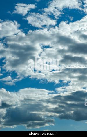 Blue sky with thunderclouds. The sun breaks through the clouds. Black clouds. Stock Photo