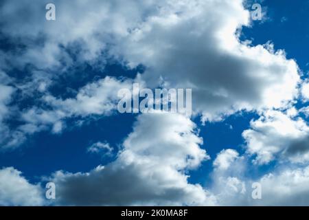 Blue sky with thunderclouds. The sun breaks through the clouds. Black clouds. Stock Photo