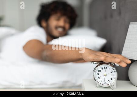 Hand turning off alarm clock waking up in the morning Stock Photo
